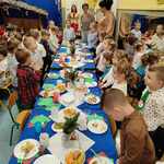 1.	Dzieci  ubrane w odświętne stroje stoją i śpiewają kolędę przy udekorowanym świątecznie stole. 