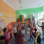 Dzieci trzymają w rękach kolorowe paski bibuły i naśladują ruch szumiących na wietrze drzew.