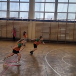 Na zdjęciu widzimy zmagania sportowe dwójki dzieci. Przedszkolaki ścigają się do mety. Zdjęcie wykonano na sali gimnastycznej.